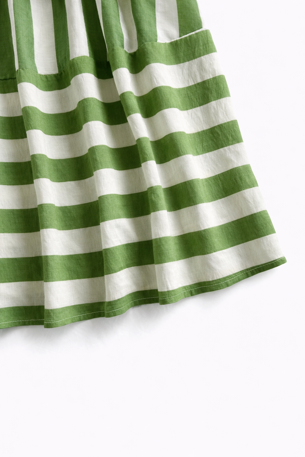 green striped maxi dress on a minimal studio background