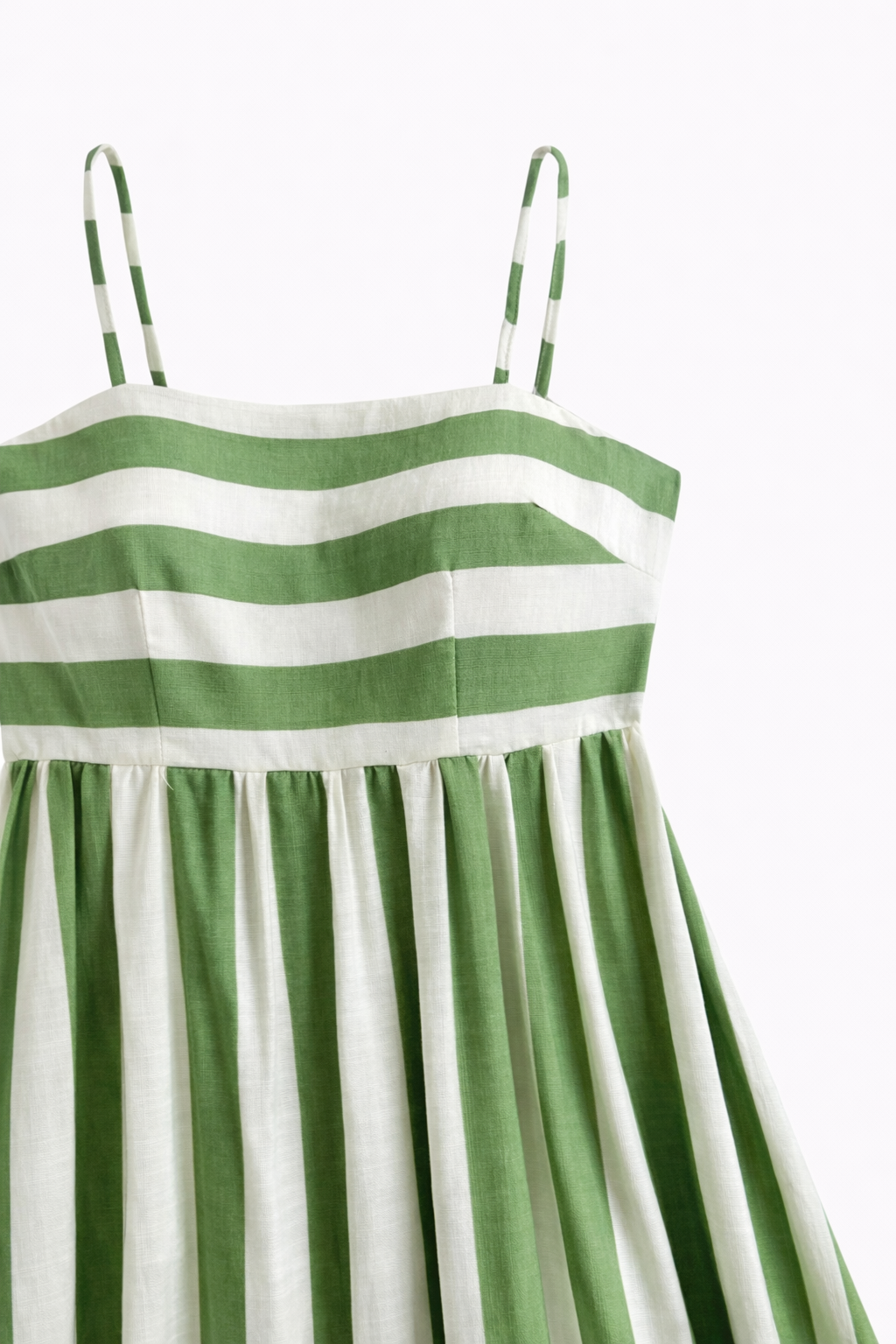 green striped maxi dress on a minimal studio background