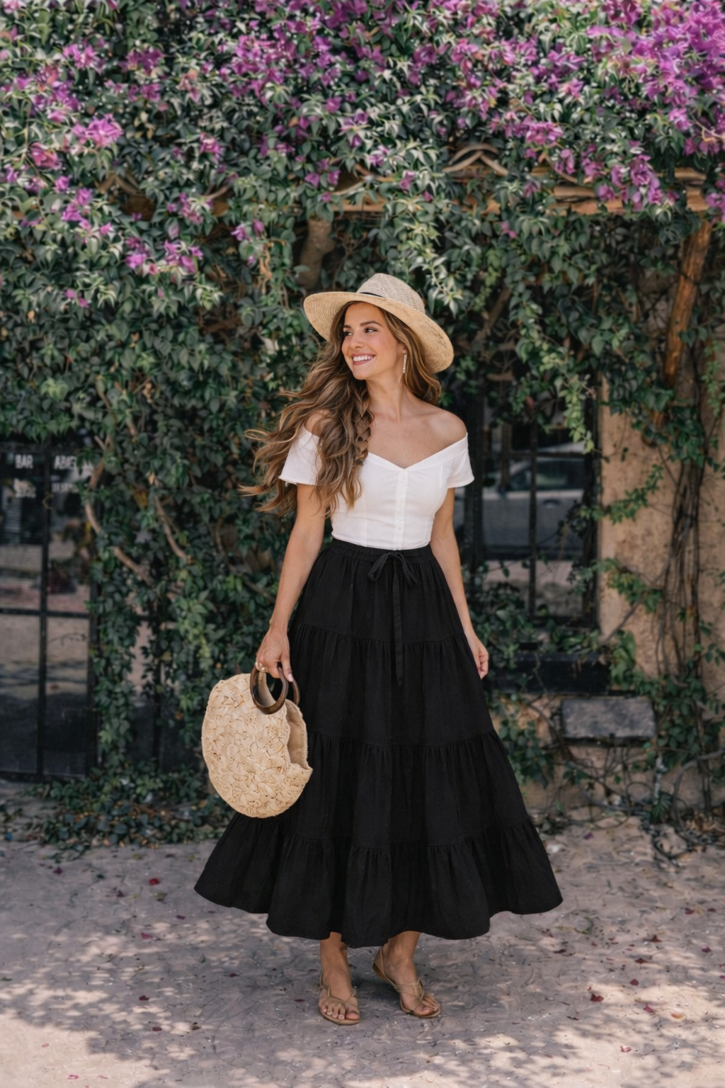 Black cotton tiered maxi skirt — sun-lit bougainvillea backdrop — RIVI